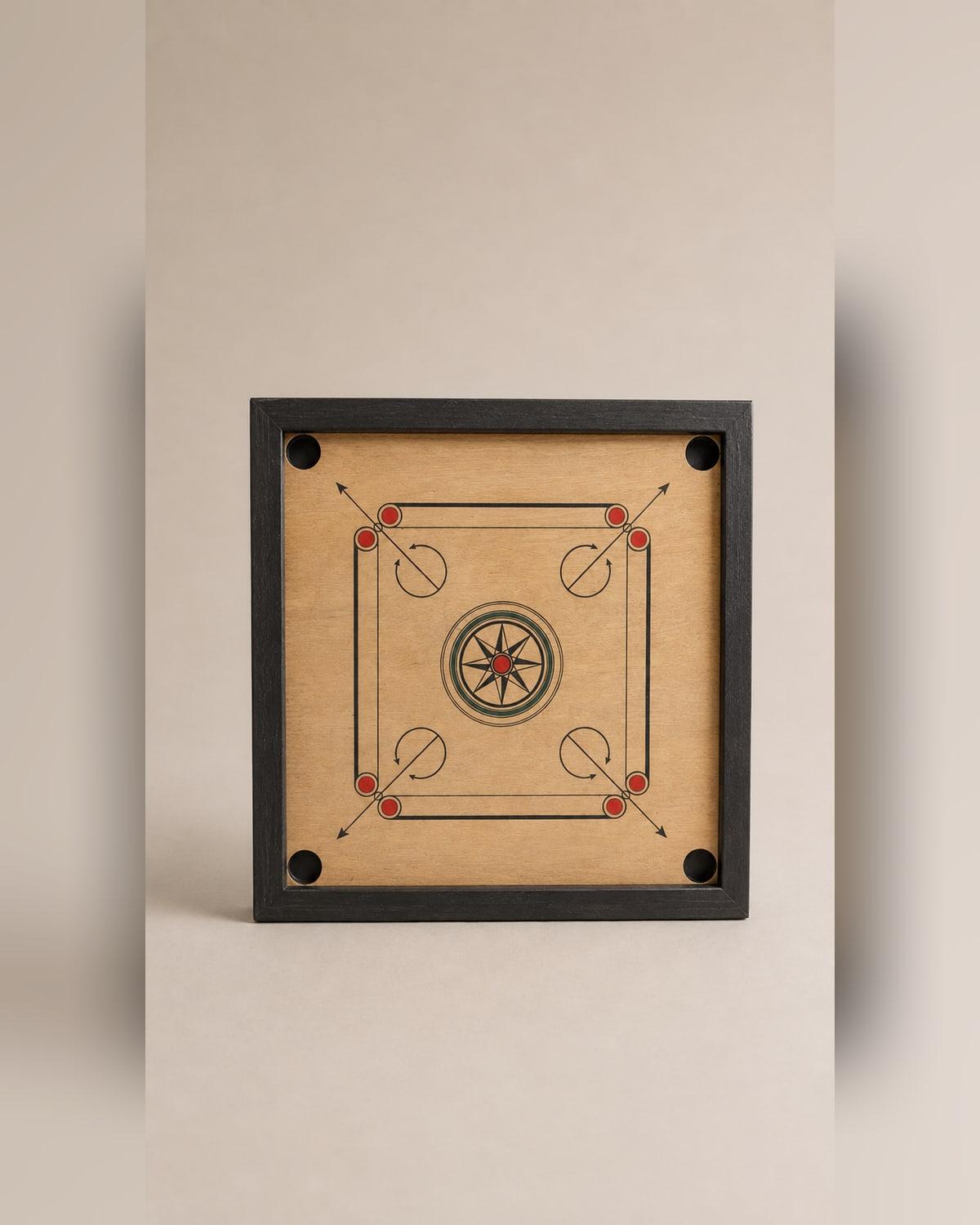 A carrom board standing upright, its plywood playing surface printed with a central star, corner arrows and red and black circles, framed in a dark timber edge with a net pocket at each corner.