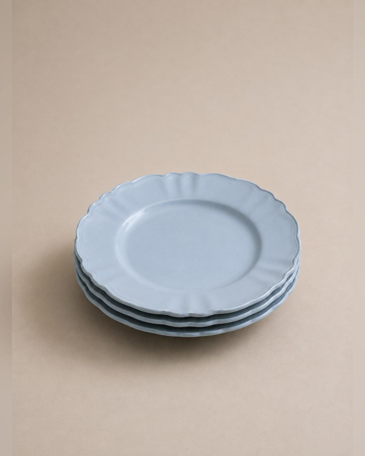 Three pale blue side plates stacked, with a scalloped edge and shallow fluting running from the rim towards the centre, in a soft matte glaze.
