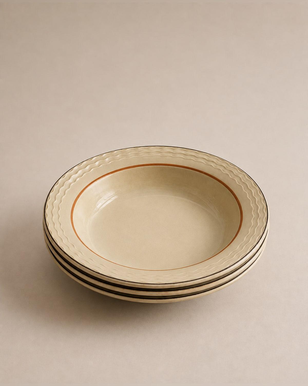 Three deep cream soup plates stacked, each with a rippled wave moulding around the wide rim, a thin orange line inside the well and a dark band at the outer edge.